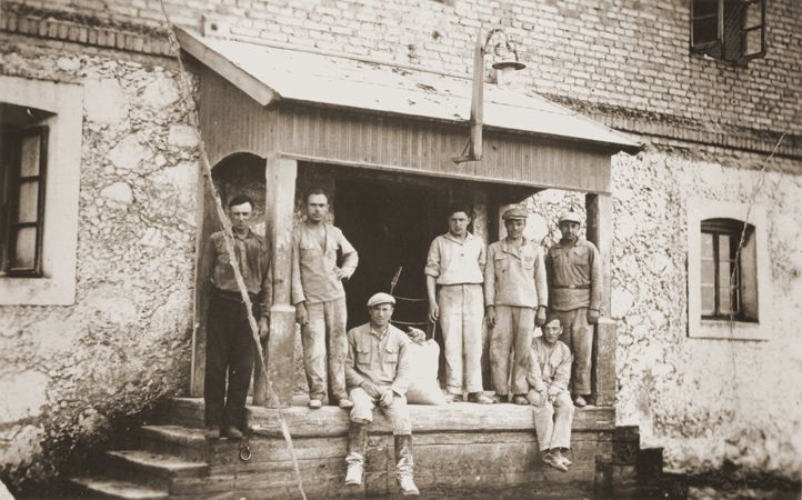 Jewish workers pose on the porch of a mill in Lyubcha